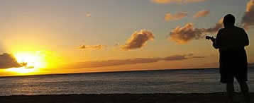 Ukelele player on beach at sunset